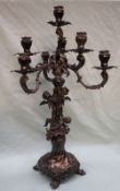 A continental white metal seven branch candleabra, the column decorated with winged cherubs,