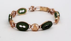A Chinese jade and yellow metal bracelet with oval and circular links, marked 14k,