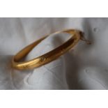 An 18ct gold hinged bracelet with star decoration,