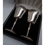 A pair of Elizabeth II silver goblets, decorated with grapes and leaves,