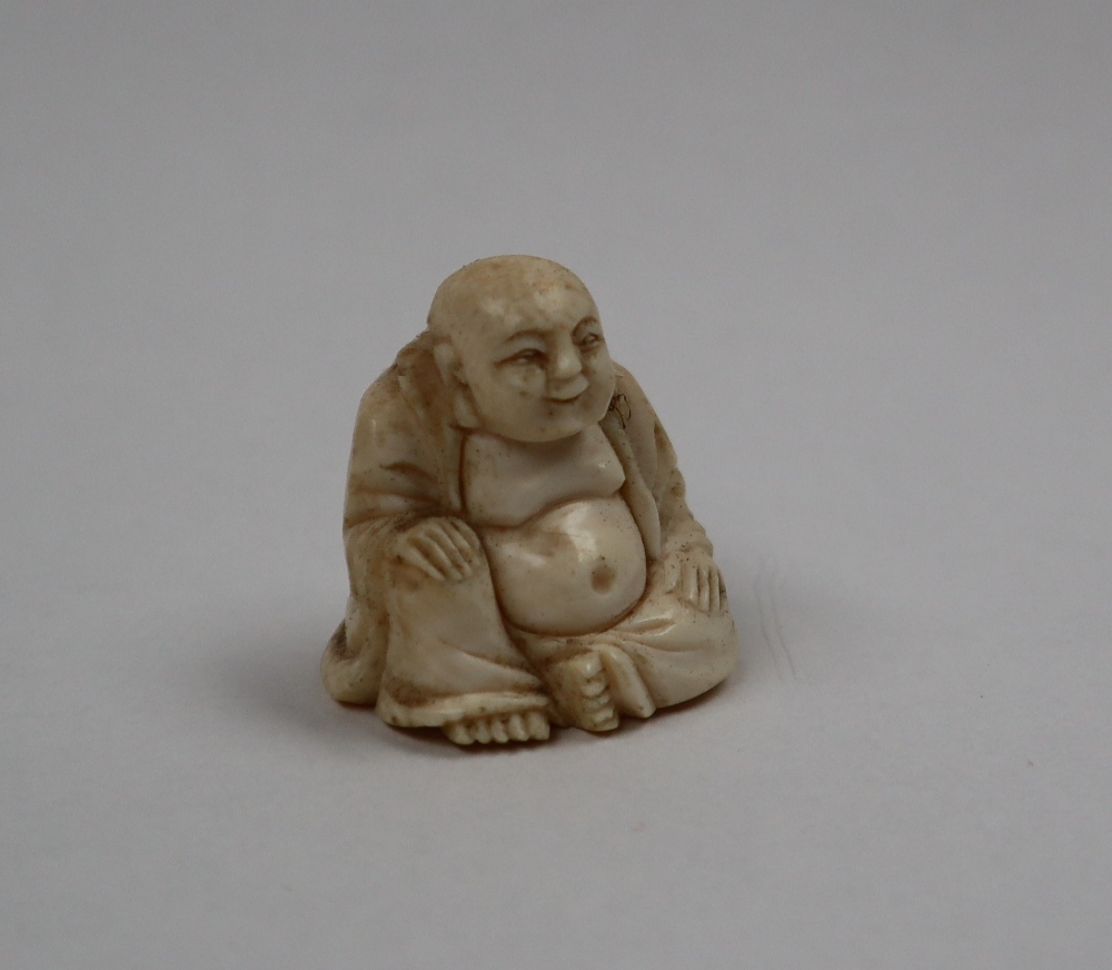A late 19th / early 20th century ivory figure of Hotei, seated with his right hand on his knee, - Image 6 of 9