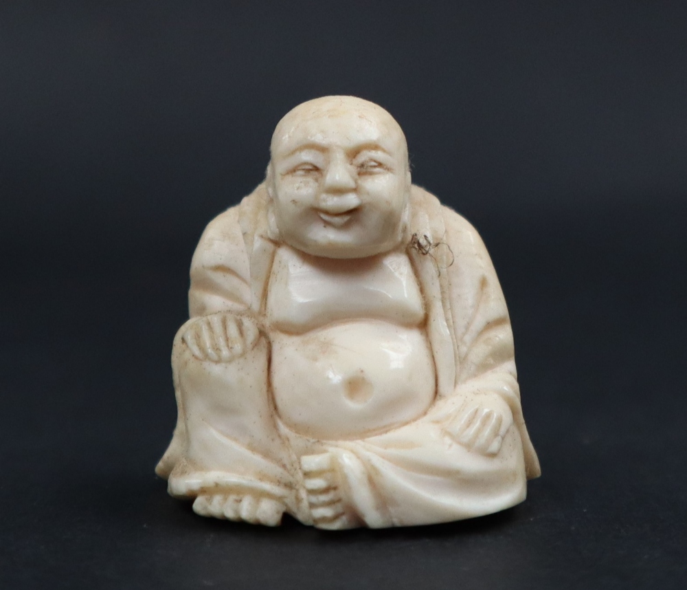 A late 19th / early 20th century ivory figure of Hotei, seated with his right hand on his knee,