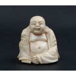A late 19th / early 20th century ivory figure of Hotei, seated with his right hand on his knee,