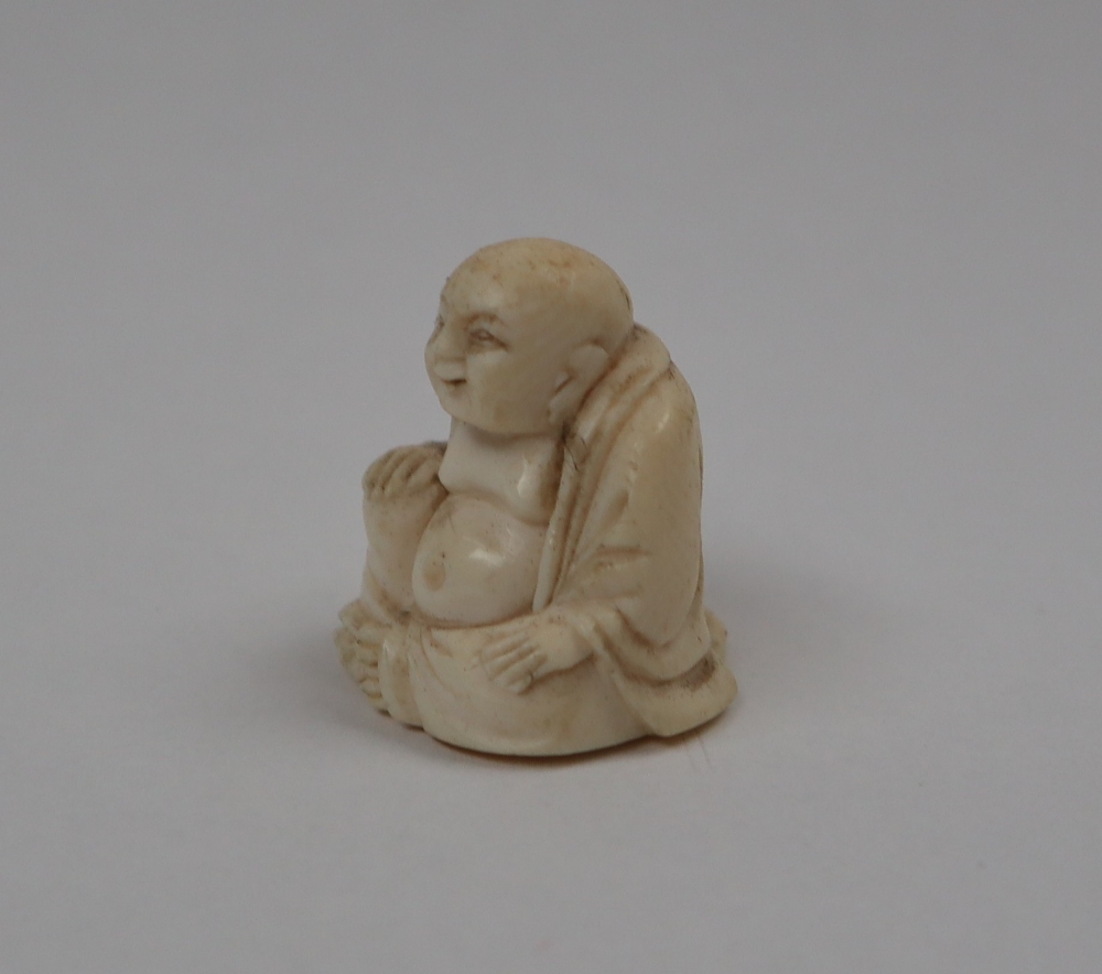 A late 19th / early 20th century ivory figure of Hotei, seated with his right hand on his knee, - Image 2 of 9