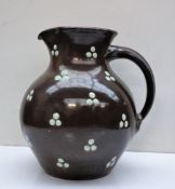 D Hallance - A studio pottery jug, with a mottled grey ground applied with green beads,
