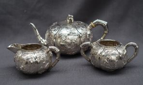 A Chinese silver three piece teaset, comprising a teapot, cream jug and twin handled sugar basin,