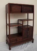 A Chinese hardwood side cabinet the rectangular top above a pair of sliding doors and shelves,