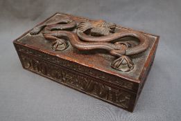 A Chinese hardwood hinged box and cover, the lid carved with a five toed dragon,