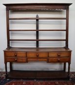 An 18th century South Wales oak dresser, the open rack with a moulded cornice and three shelves,