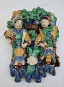 A Chinese pottery wall pocket, depicting figures before a bower of trees,