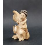 A late 19th / early 20th century figure of a Geisha seated upon a dog,