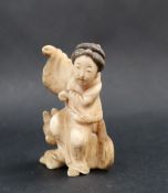 A late 19th / early 20th century figure of a Geisha seated upon a dog,