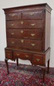 An 18th century oak chest on stand with a moulded cornice above two short and three long drawers,