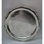 A silver tray of circular form,. with a wave rim, marks indistinct, 31.