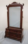 An 18th century walnut toilet mirror with a shield shaped plate and six drawers on bracket feet,