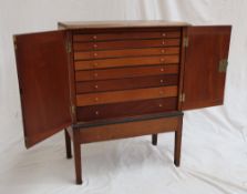 A George III walnut collectors cabinet with a rectangular top above a pair of cabinet doors