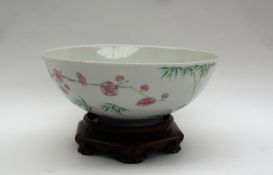 A Chinese porcelain bowl, the exterior decorated with blossom, bamboo and insects,