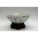 A Chinese porcelain bowl, the exterior decorated with blossom, bamboo and insects,