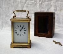 A 19th century brass cased carriage timepiece with an enamel dial and Roman numerals 14.