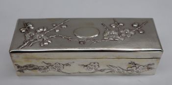 A Chinese silver hinged box and cover, of rectangular form decorated with blossom trees,