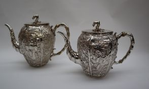 A Chinese silver hot water pot and teapot, with panels decorated with figures, birds,