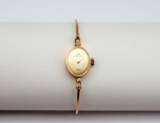 A lady's 18ct yellow gold wristwatch, the oval gilt dial inscribed C.