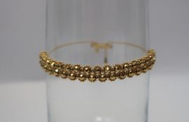 A 9ct yellow gold bracelet with faceted bead decoration, approximately 11.