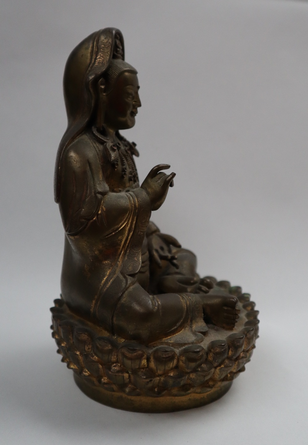 A Bronze figure of Quan yin, seated with right hand raised and left hand resting on her leg, - Image 6 of 9