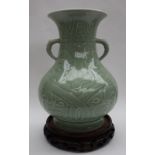 A Chinese celadon vase, with a flared neck and a twin handled baluster body on a spreading foot,