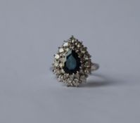 An 18ct white gold sapphire and diamond cluster ring set with a pear shaped sapphire,