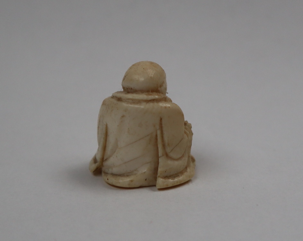 A late 19th / early 20th century ivory figure of Hotei, seated with his right hand on his knee, - Image 4 of 9
