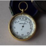 A yellow metal compensated pocket barometer, with a silvered dial,