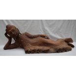 A carved hardwood recumbent buddhistic figure, in traditional dress,