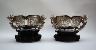 A pair of Chinese silver bowls of circular lobed form with six panels, decorated with dragons,