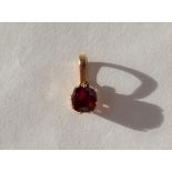 A solitaire ruby pendant, of cushion shape in an 18ct yellow gold claw setting and loop,