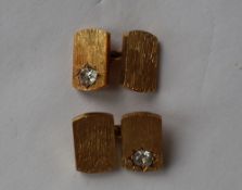 A pair of 18ct textured yellow gold cufflinks, both set with a cushion cut diamond,