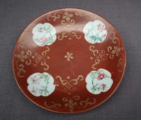 A Chinese porcelain dish of circular form, with a red ground and gilt highlights,