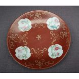 A Chinese porcelain dish of circular form, with a red ground and gilt highlights,