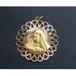 An 18ct yellow gold pendant of pierced circular form, with a head in profile, 47mm diameter,