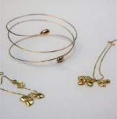 A 9ct gold spring bangle together with two 9ct gold bracelets with heart drops,