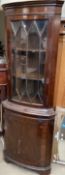 A reproduction mahogany standing corner cupboard