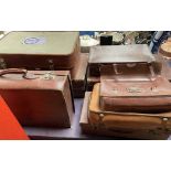 A leather suitcase together with a collection of suitcases and briefcases