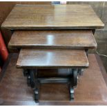 An oak nest of three tables with rectangular tops and shaped supports