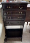 An Edwardian mahogany music cabinet with a rectangular top above four drawers with drop fronts and