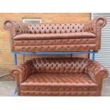 A pair of brown leather chesterfield three seater settees on bun feet