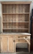 A 19th century pine dresser, with a moulded cornice above three shelves, the base with a cupboard,