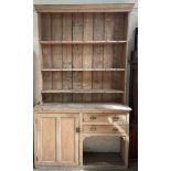 A 19th century pine dresser, with a moulded cornice above three shelves, the base with a cupboard,