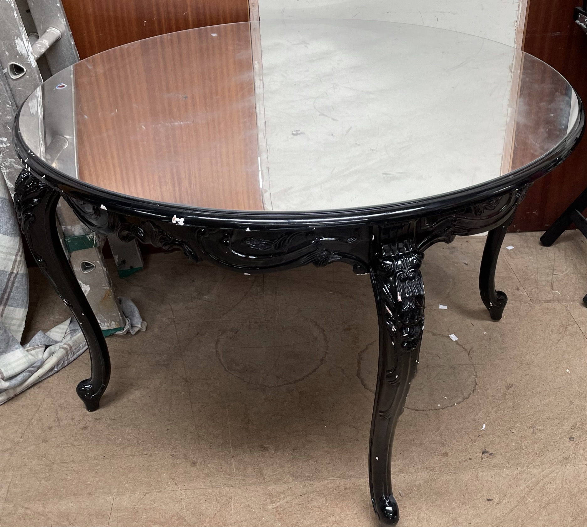 A Black painted shop display table with a mirrored top together with three make up artists