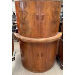 A Art Deco inspired walnut drinks cabinet, of D shape, the top doors enclosing a mirrored interior,