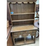 A 20th century oak dresser, with a moulded cornice above two shelves,